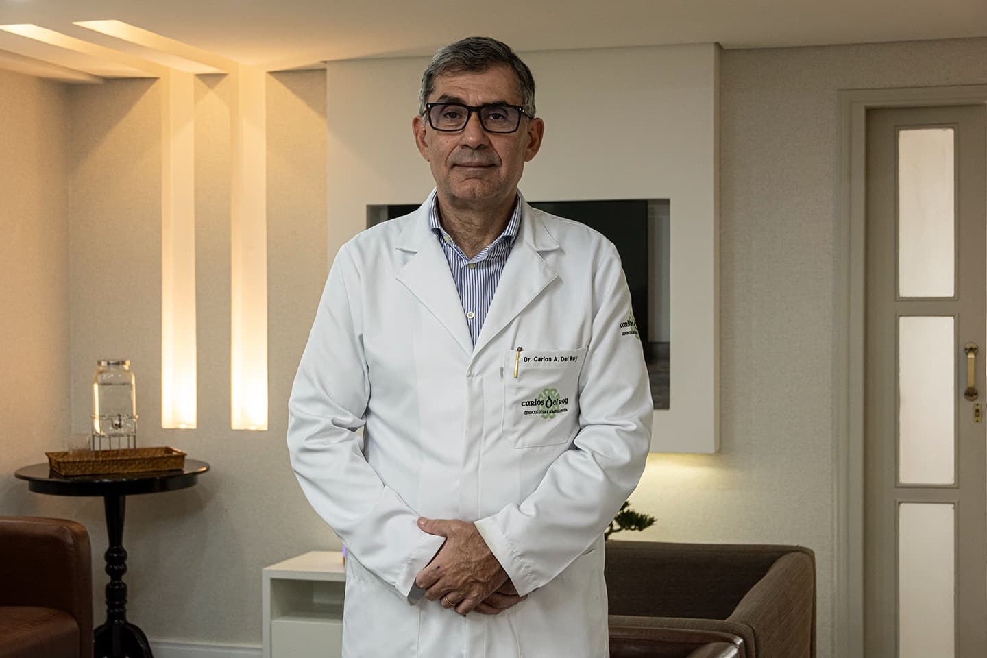 Dr. Carlos Del Roy em pé na sala de espera do consultório no Itaim Bibi.